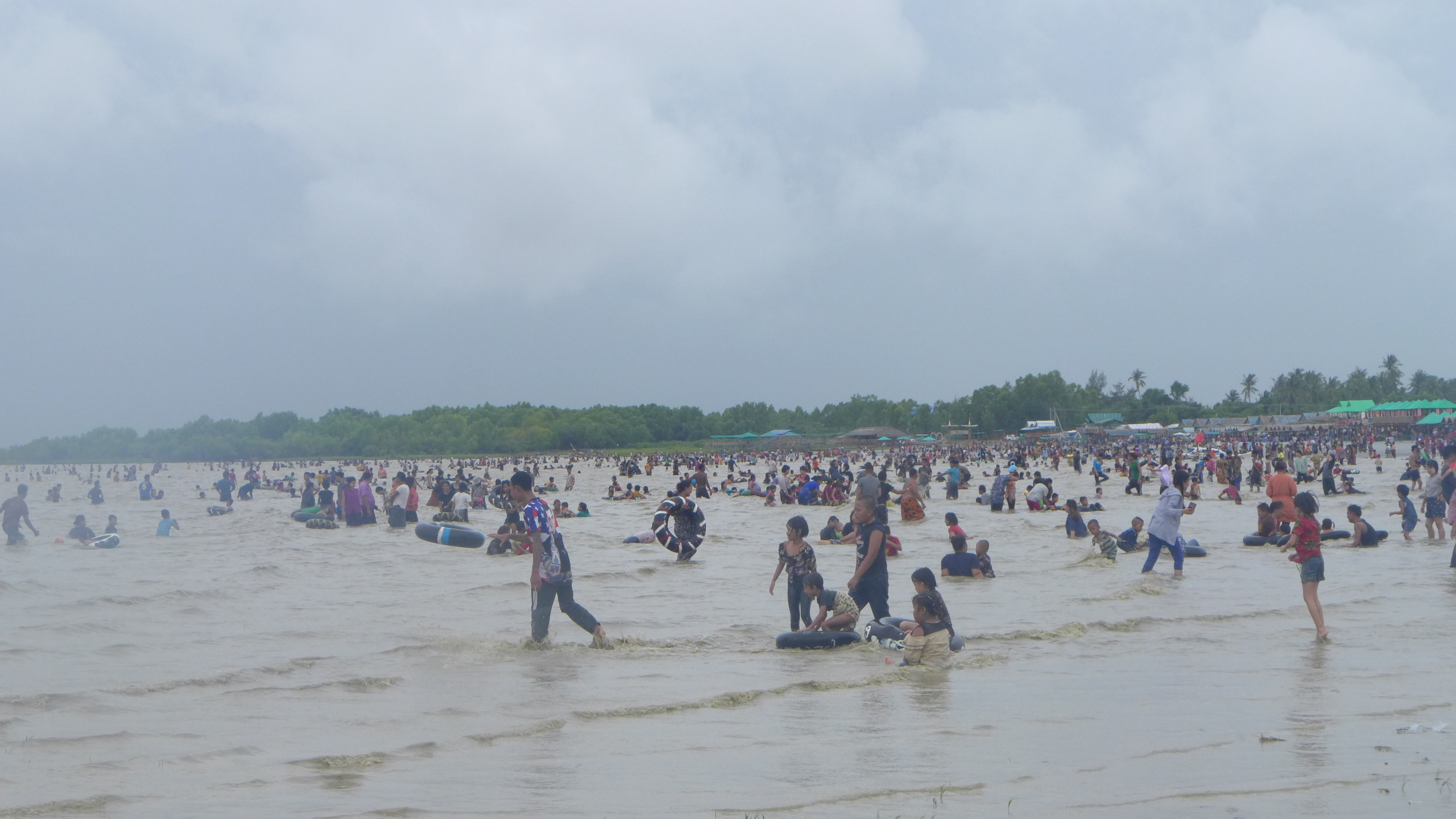 ပင်လယ်ကမ်းစပ်၌ ကလေးငယ်များ ပျော်ပျော်ရွှင်ရွှင် ရေဆော့ကစားနေစဉ်